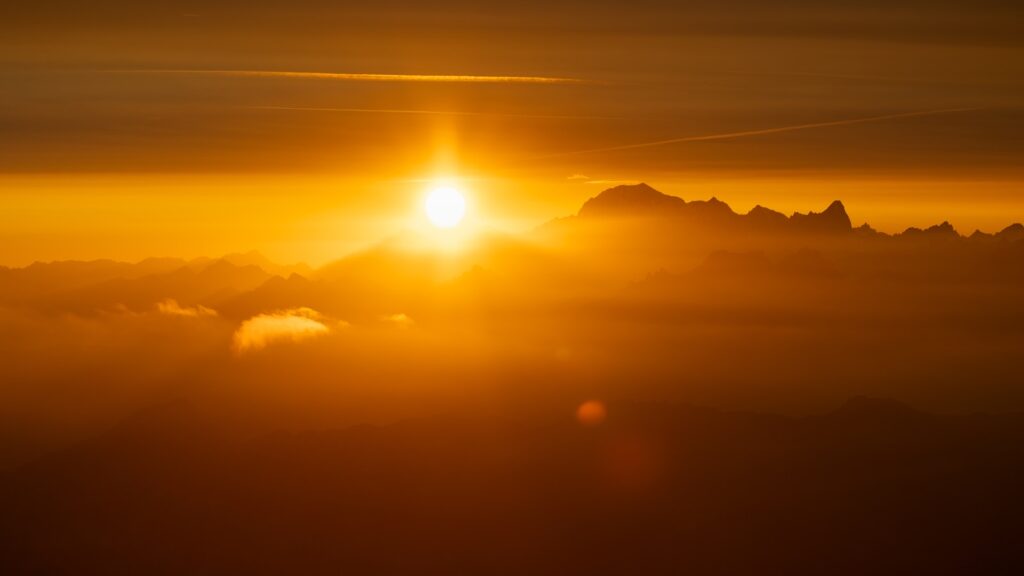 The sun shines through golden clouds.